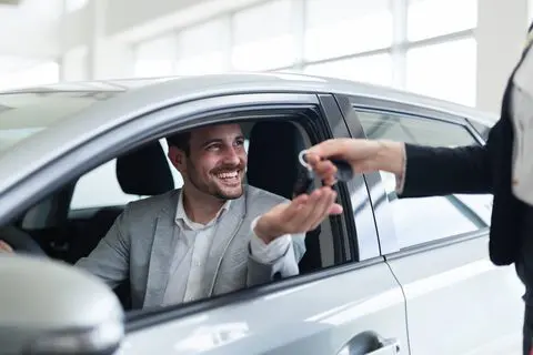 Customer collecting car keys – DVLA vehicle tax and motoring help at Gale Street Post Office, Rochdale