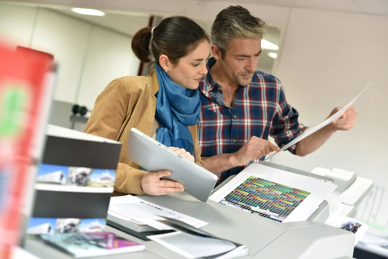 Customers reviewing colour print documents at a professional printing service