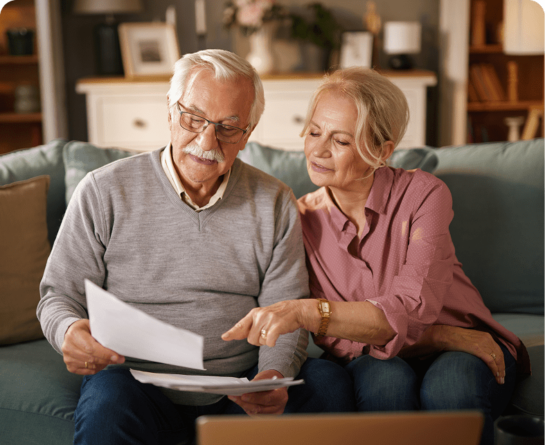 Seniors discussing paperwork on couch
